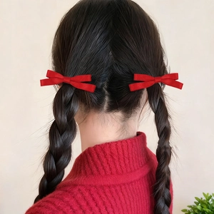 Détail de nœuds rouges sur tresses pour un look doux style balletcore esthétique