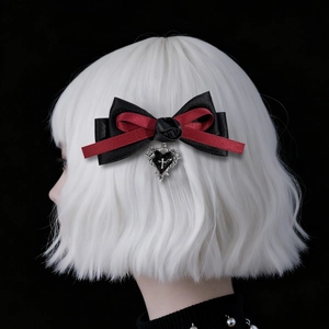 Detail of gothic bow hair clip with black rose and heart cross pendant on a wig