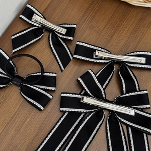 Set classico di fermagli per capelli e elastico con fiocco bianco e nero su legno