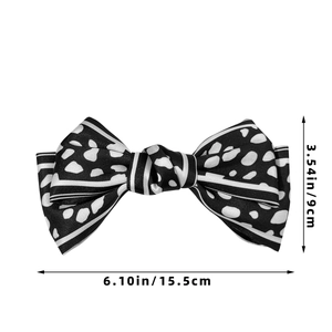 Detail view of large satin bow hair clip with black and white leopard pattern and size labels
