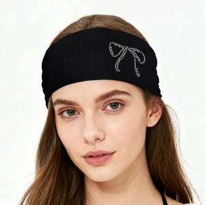 Detail of black ribbed elastic headband featuring a silver rhinestone bow decoration