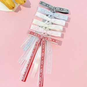 Lace bow hair clips with long streamers in multiple colors on a pink background