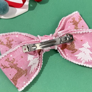 Vista posteriore del fiocco di Natale rosa con renna dorata e motivi di alberi bianchi
