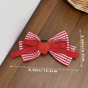 Close-up of red plaid bow hair clip with 3D strawberry detail and size measurements