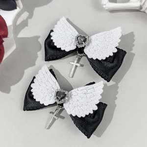 Détail de pinces à cheveux gothiques avec nœuds noirs et ailes d'ange blanches