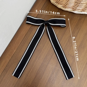 Dettaglio di un fiocco per capelli nero con cuciture bianche e dimensioni di 14x21 cm