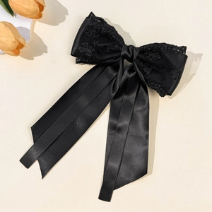 Vue détaillée des couches de dentelle noire et ruban de satin de la pince à cheveux