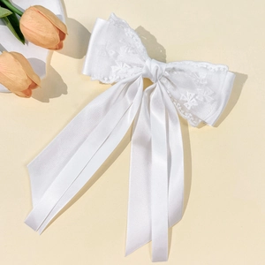 Détails de la pince à cheveux en satin blanc et dentelle avec broderie florale