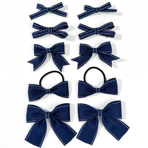 Dettaglio del set di 10 fiocchi per capelli blu scuro con cuciture bianche a contrasto