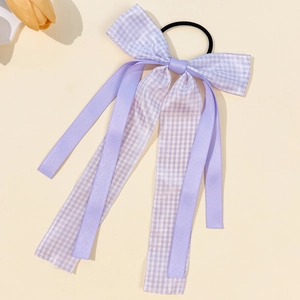 Detail view of long purple ribbon bow hair tie with plaid pattern and elastic band