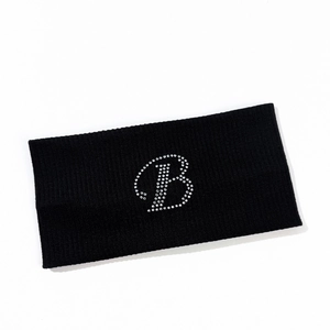 Detailed view of knitted black headband featuring a sparkling rhinestone letter B pattern