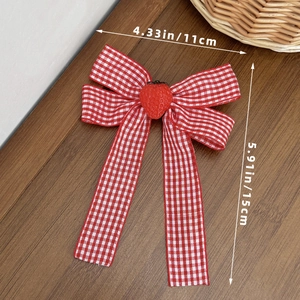 Detail showing red checkered bow hairpin with strawberry charm and dimensions on wood