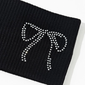 Close-up of black ribbed fabric headband with sparkling rhinestone bow pattern detail