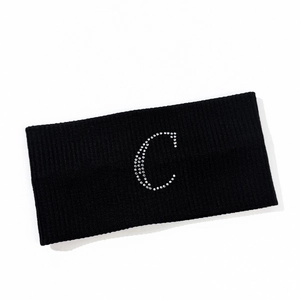 Detail of black elastic knitted headband featuring a silver rhinestone letter C design
