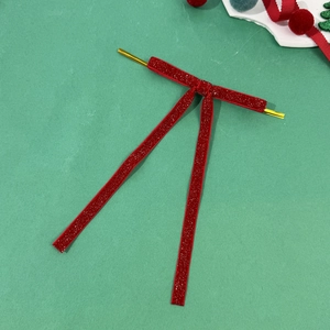 Detail of red velvet Christmas bow with gold twist tie for festive tree decoration