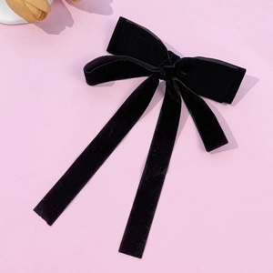 Detail of vintage black velvet bow hair clip with elegant long flowing ribbons