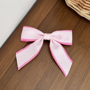 Dettaglio di un fiocco in nastro grosgrain rosa con eleganti bordi a contrasto