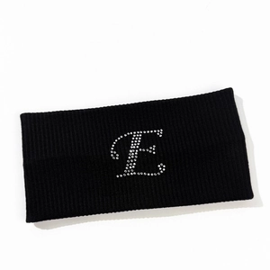 Close-up of black ribbed knit sports headband with a sparkling rhinestone letter E design