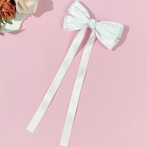 Elegant long white satin ribbon bow hair clip with glossy silk texture for women