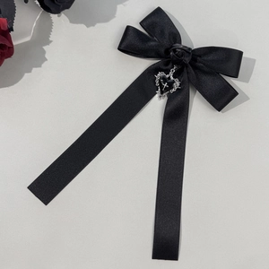 Detail of gothic black satin bow hair clip with rose and silver heart cross pendant