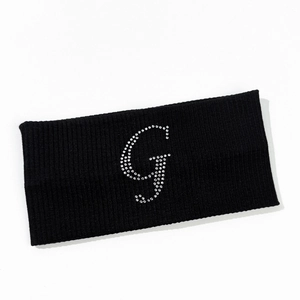 Detailed texture of black elastic knitted sports headband with rhinestone letter G