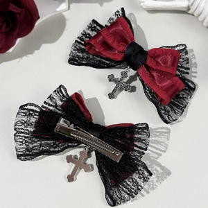 Detail of gothic bow hair clips with dark red satin, black lace, and silver cross pendants