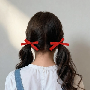Détail de nœuds de cheveux rouges en ruban sur deux couettes pour filles, lumière douce