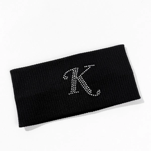 Detail of black ribbed knit sports headband featuring a sparkling rhinestone letter K