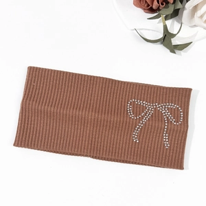 Close-up of brown ribbed knit headband with sparkling rhinestone bow detail