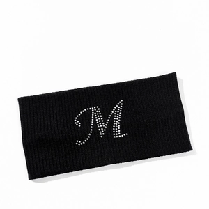 Detail shot of black ribbed knit sports headband featuring silver rhinestone M letter design