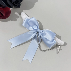 Detail of gothic light blue bow hair clip with plush wings, metal chain and cross charm