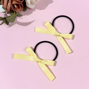 Lot de deux chouchous à nœuds jaunes sur fond rose avec décorations florales