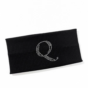 Detail of black ribbed sports headband featuring a sparkling rhinestone letter Q design