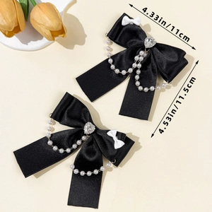Dettaglio di fermagli per capelli a fiocco nero con catene di perle e misure 11x11,5 cm