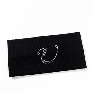 Close-up of black knitted elastic headband with sparkling silver rhinestone letter detail