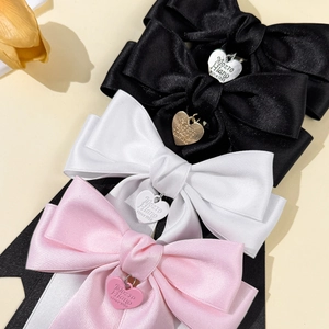 Elegant satin bow hair clips in black white and pink with heart pendants and ribbons