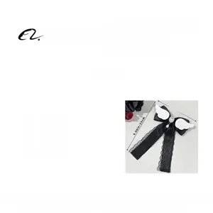 Détail du nœud de cheveux en dentelle noire avec ailes d'ange et pendentif en perles