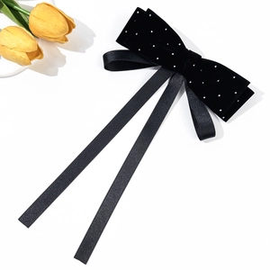 Detail of French velvet bow hair clip with sparkling rhinestones and long satin streamers