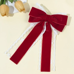 Elegant red velvet bow hair clip with white lace trim and long flowing ribbons