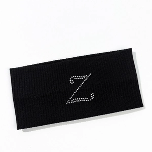 Macro detail of elastic black knitted headband featuring a silver rhinestone letter Z motif