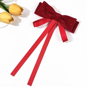 Detailed macro view of French vintage red velvet bow hair clip with rhinestone accents