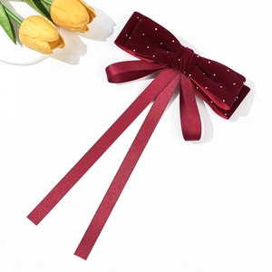 Elegant wine red velvet bow hair clip with silver beads and long ribbons on white background