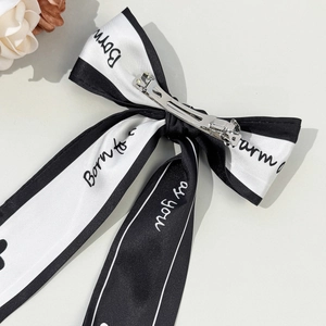 Elegant black and white bow hair clip with chic script print and silver metal spring fastener