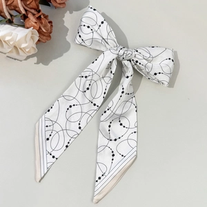 Elegant white bow hair ribbon with black geometric pattern and long silk scarf streamers