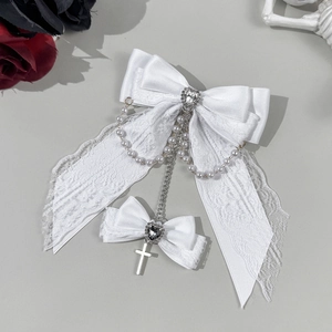 Detail of white lace bow hair clip with heart rhinestone, pearl chains and cross charm