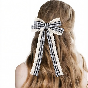 Detail of gingham bow hair clip with lace trim and long ribbons on blonde hair