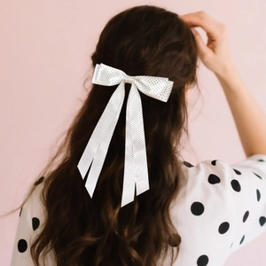 Vista dettagliata di un fermaglio per capelli con fiocco bianco a pois in stile francese
