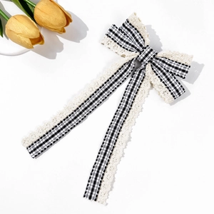 Detail of a vintage plaid bow hair clip with delicate lace edges and long streamers