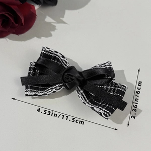 Detail view of plaid bow hair clip with black silk rose showing 11.5cm length dimensions