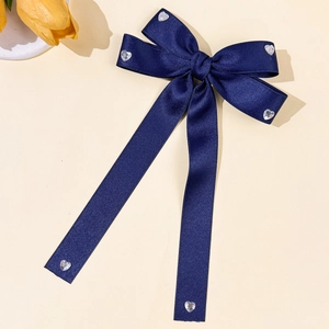 Détail du nœud en satin bleu marine avec d'élégants strass en forme de cœur brillant